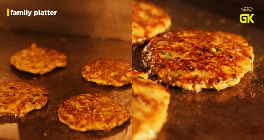 Patties searing on a flat-top grill, a still from a restaurant TV commercial